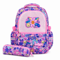 A pink and purple patterned school backpack with a matching pencil case, featuring a glittery pink front pocket with a flower patch and cartoon graphics.