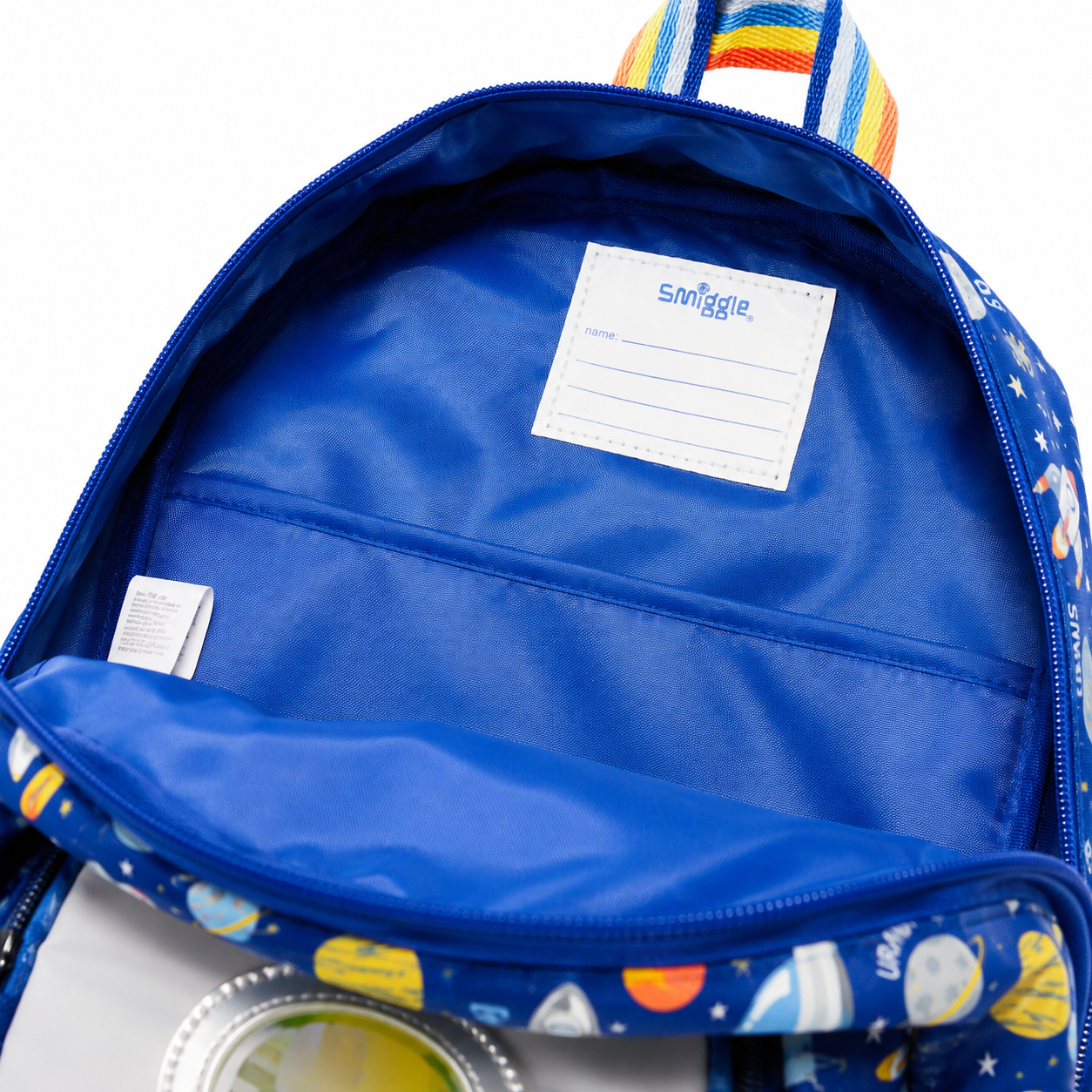 Open blue backpack showing the interior lining and a white name label that reads Snuggle. The backpack exterior has a space-themed print with planets, stars, and colorful accents.